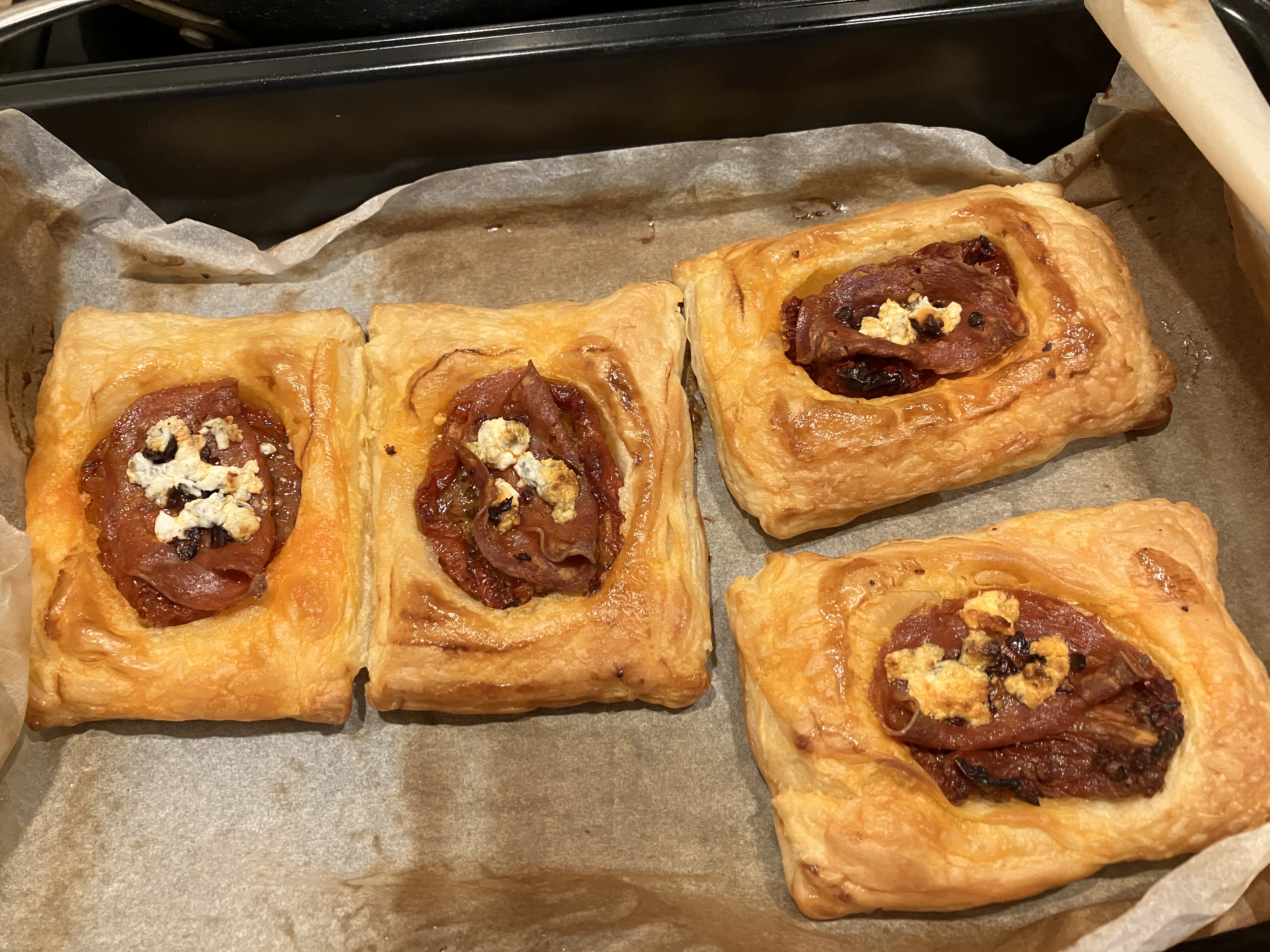 four of the same pastries on a sheet of baking paper